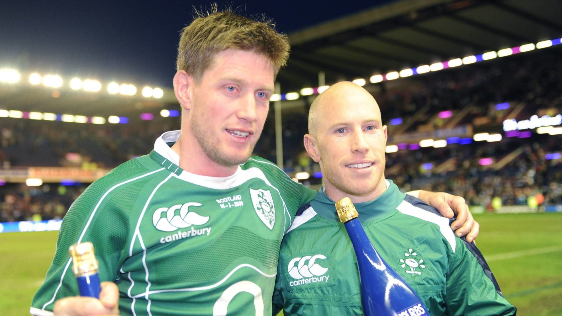 Ronan O'Gara and Peter Stringer hold bottles of champagne after winning the 2009 Grand Slam.