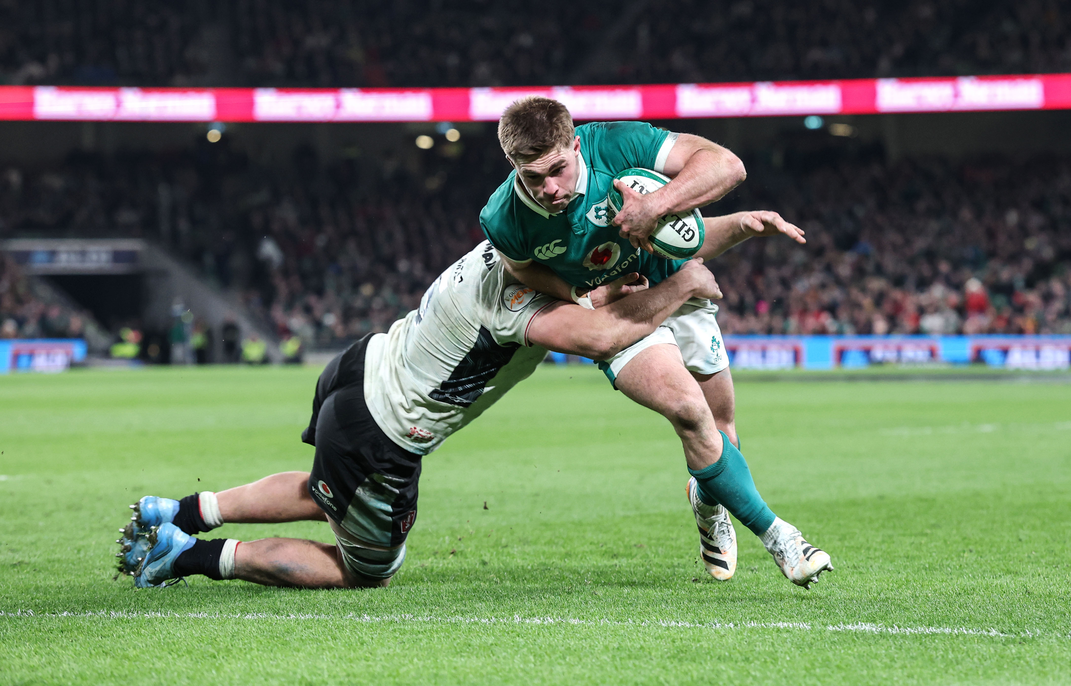 Ireland's Jack Crowley scores a try despite Wales' Ben Carter's efforts during the 2026 Guinness Six Nations Championship Round 4 game between Ireland and Wales in the Aviva Stadium, Dublin, I