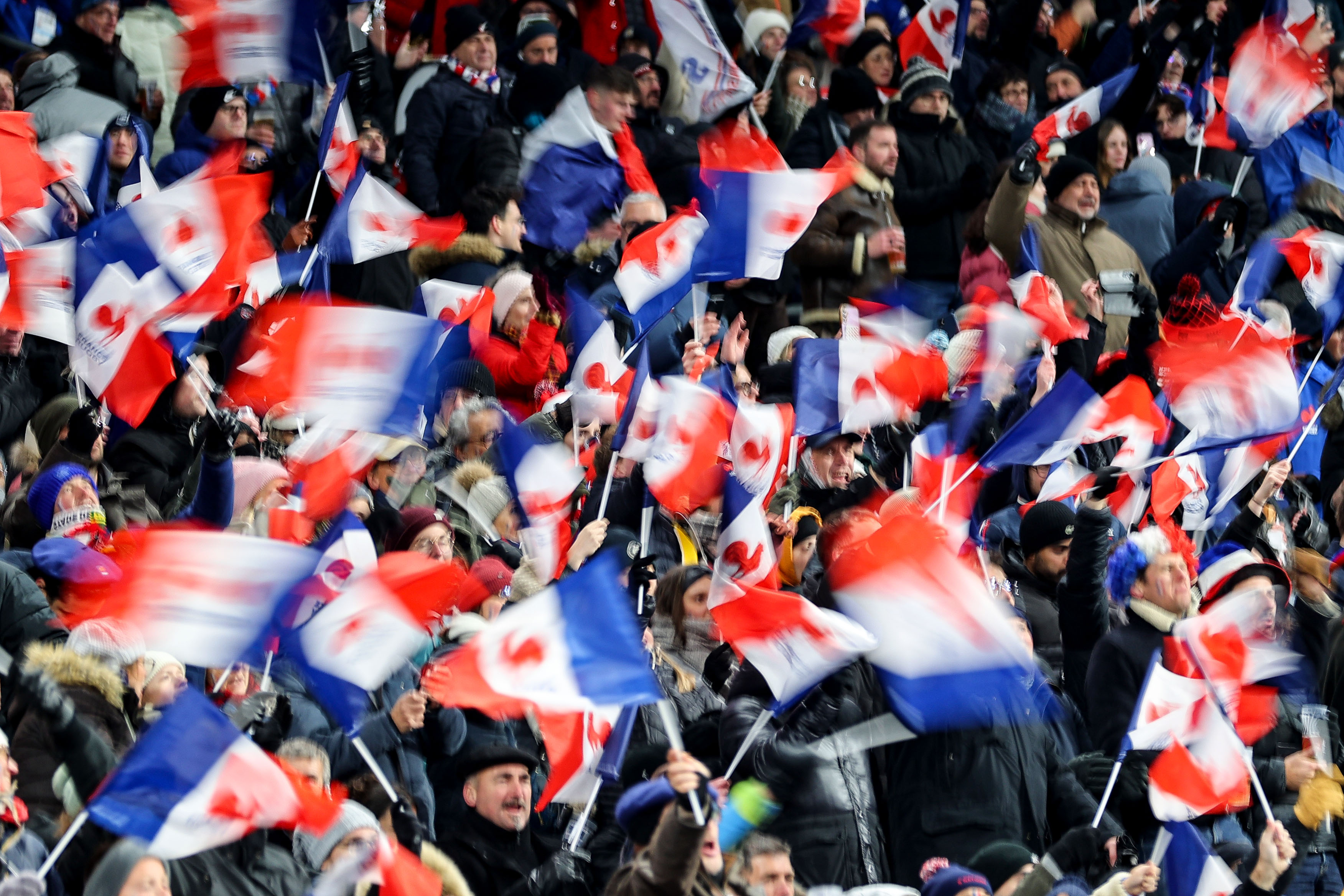 French fans in the crowd at Stade de France wave their tricolor flags.
