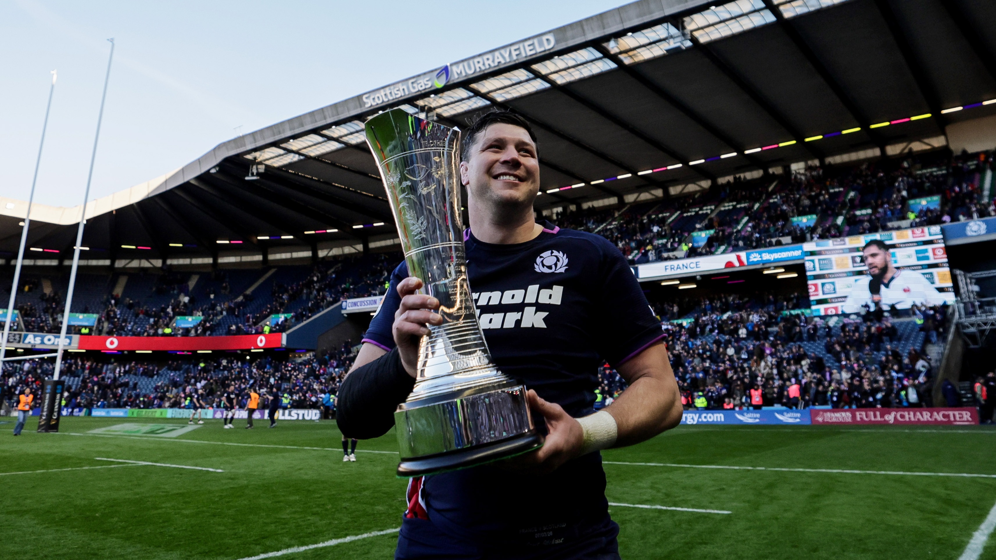 Scotland's Grant Gilchrist celebrates with the Auld Alliance trophy on the Murrayfield pitch after defeating France in the 2026 Championship.