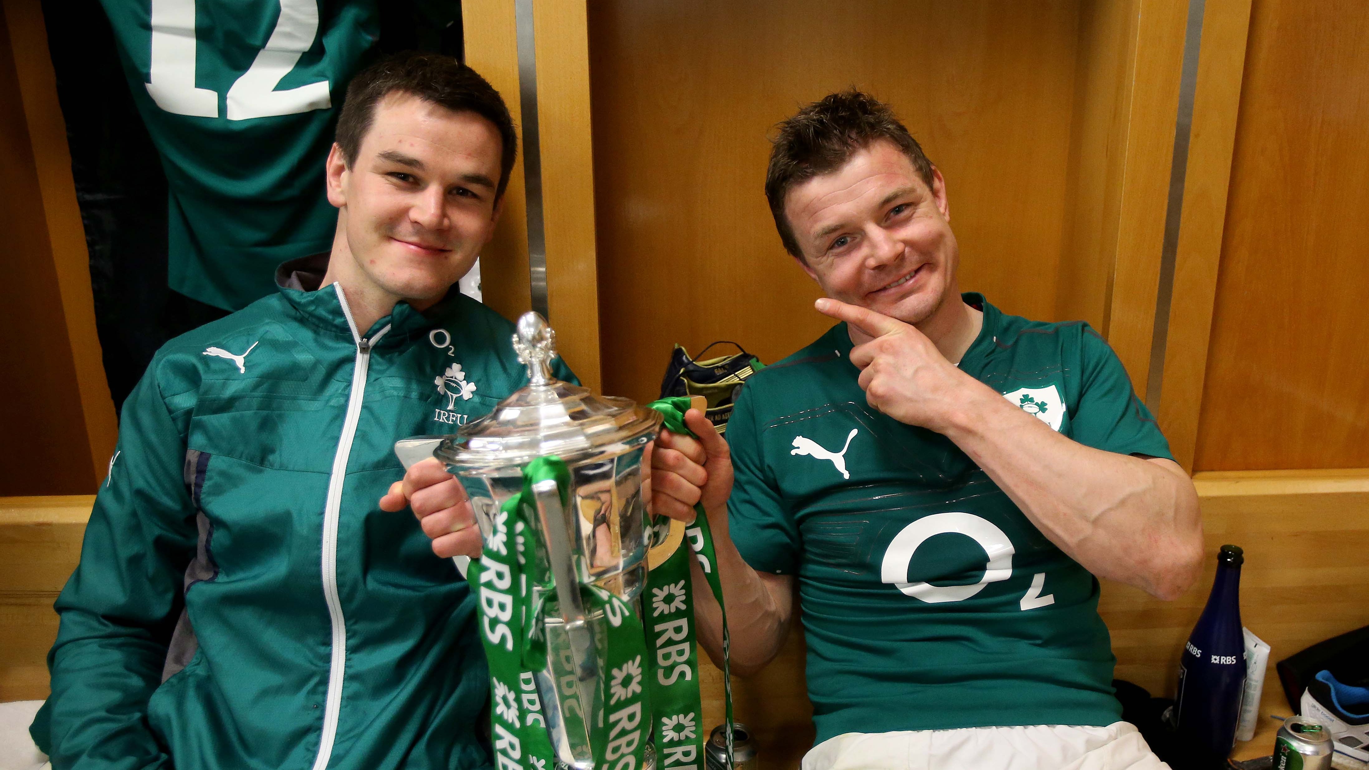 Johnny Sexton and Brian O'Driscoll celebrate in the changing room with the 2014 Championship trophy.