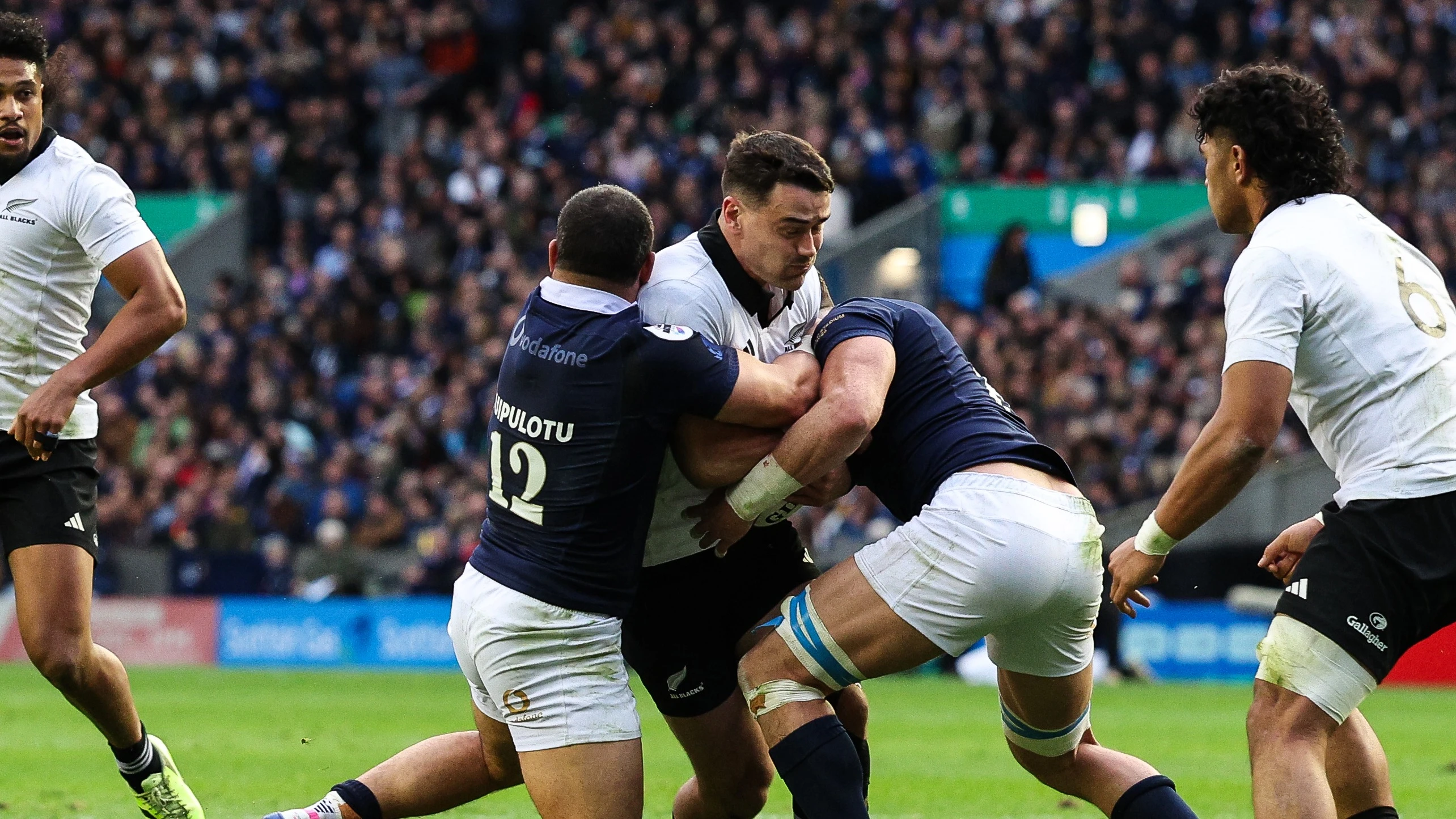 New Zealand All Blacks' Will Jordan is tackled by Scotland's Sione Tuipulotu and Jack Dempsey during the 2025 Quilter Nations Series.