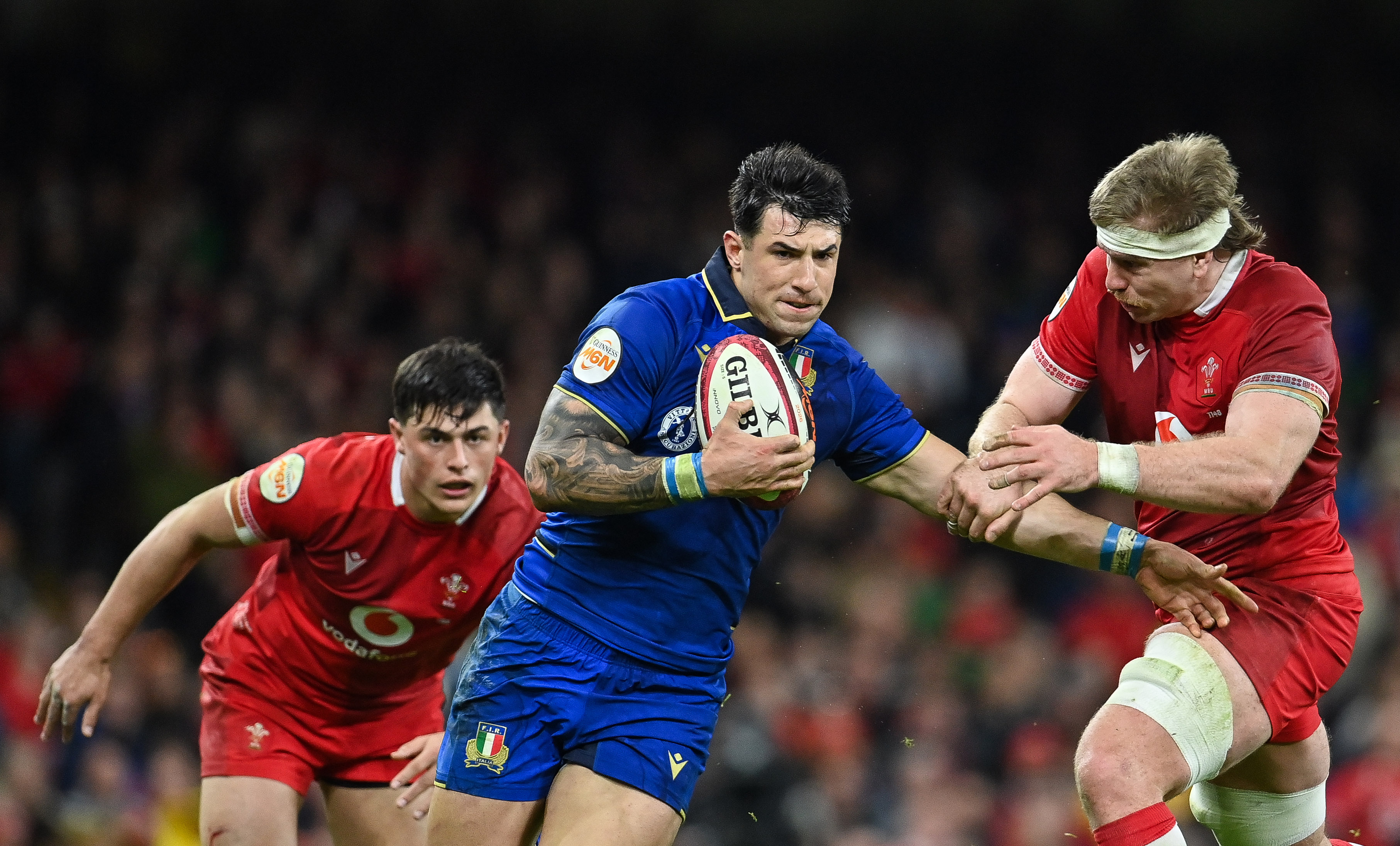 Italy's Tommaso Menoncello is tackled by Wales' Aaron Wainwright during the 2026 Guinness Six Nations Championship Round 5 game between Wales and Italy in Principality Stadium, Cardiff.