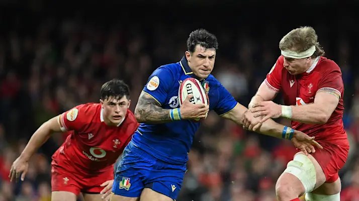 Italy's Tommaso Menoncello is tackled by Wales' Aaron Wainwright during the 2026 Guinness Six Nations Championship Round 5 game between Wales and Italy in Principality Stadium, Cardiff.