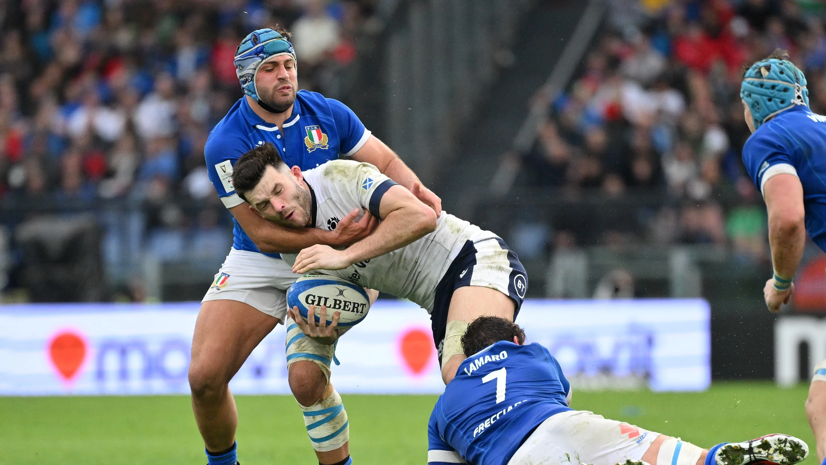 Scotland's Blair Kinghorn is tackled by Italy's Gianmarco Lucchesi and Michele Lamaro during the 2024 Guinness Six Nations Championship Round in Stadio Olimpico.