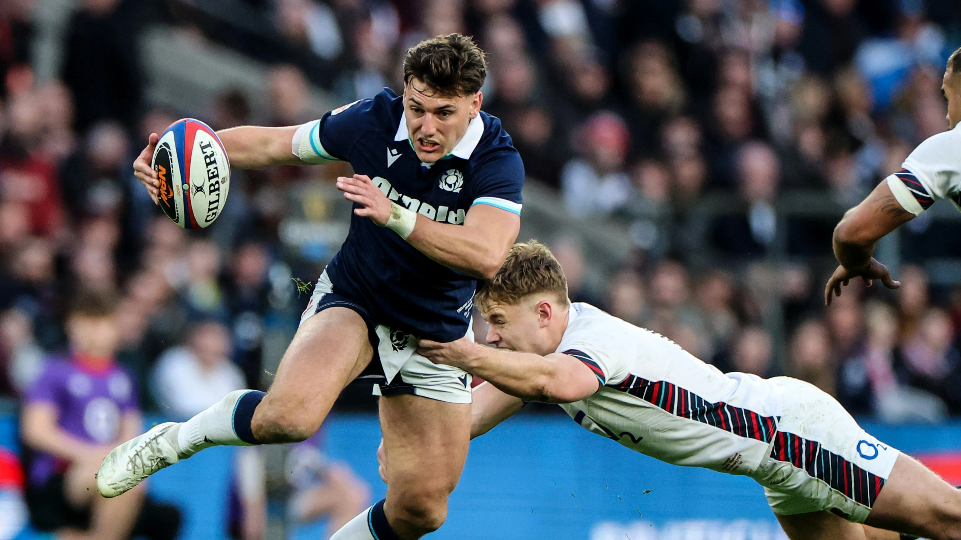 England's Fin Smith makes a lunging tackle on Scotland's Tom Jordan during the 2025 Calcutta Cup match in Twickenham.