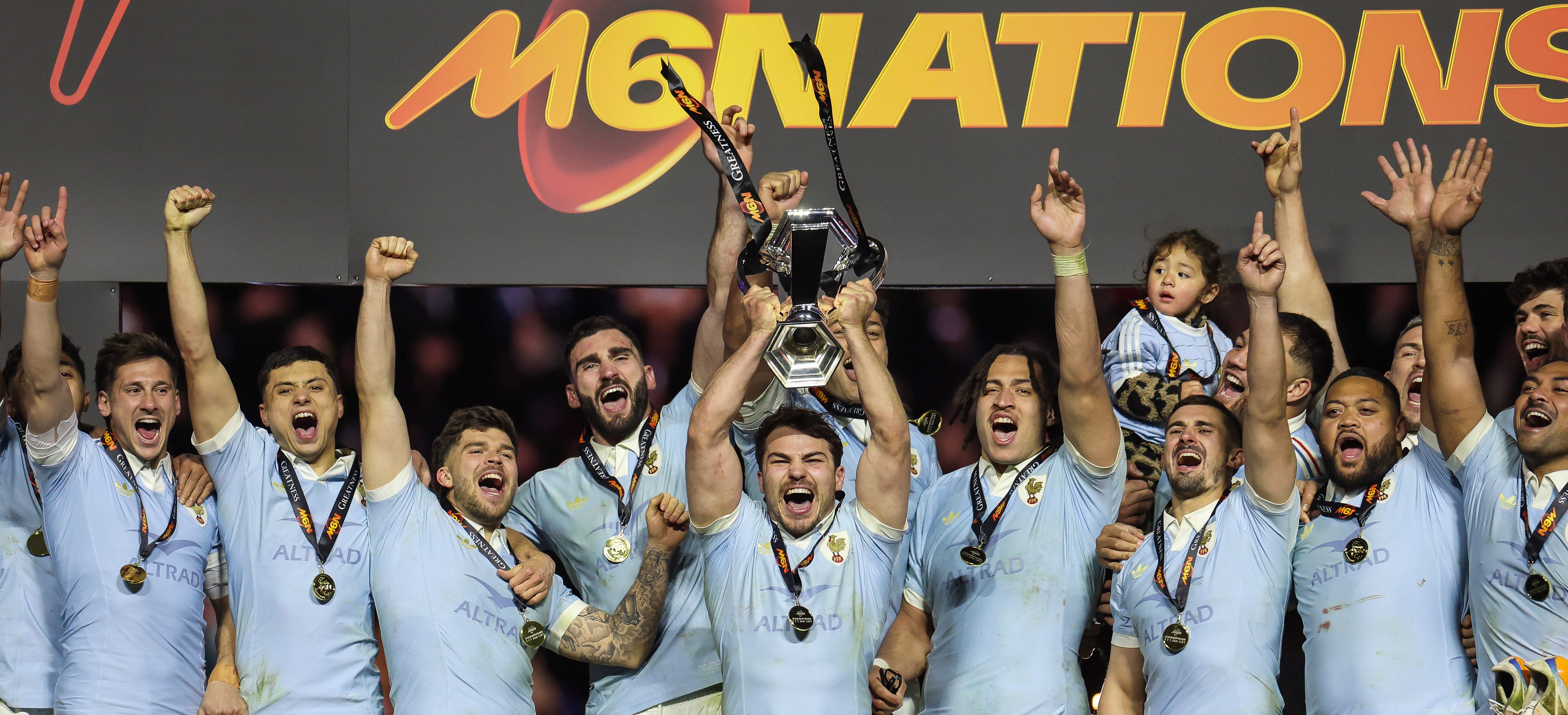 Antoine Dupont lifts the 2026 Championship trophy, flanked by his France teammates.