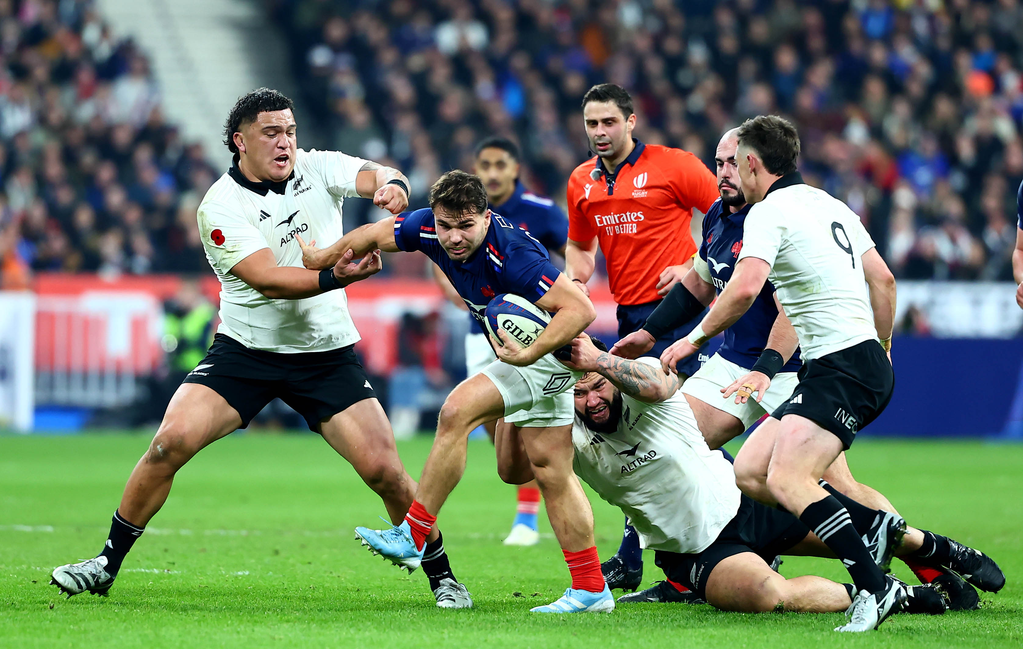 New Zealand's Tamaiti Williams tries to contain France's Antoine Dupont during the 2024 Autumn Nations Series match in Paris.