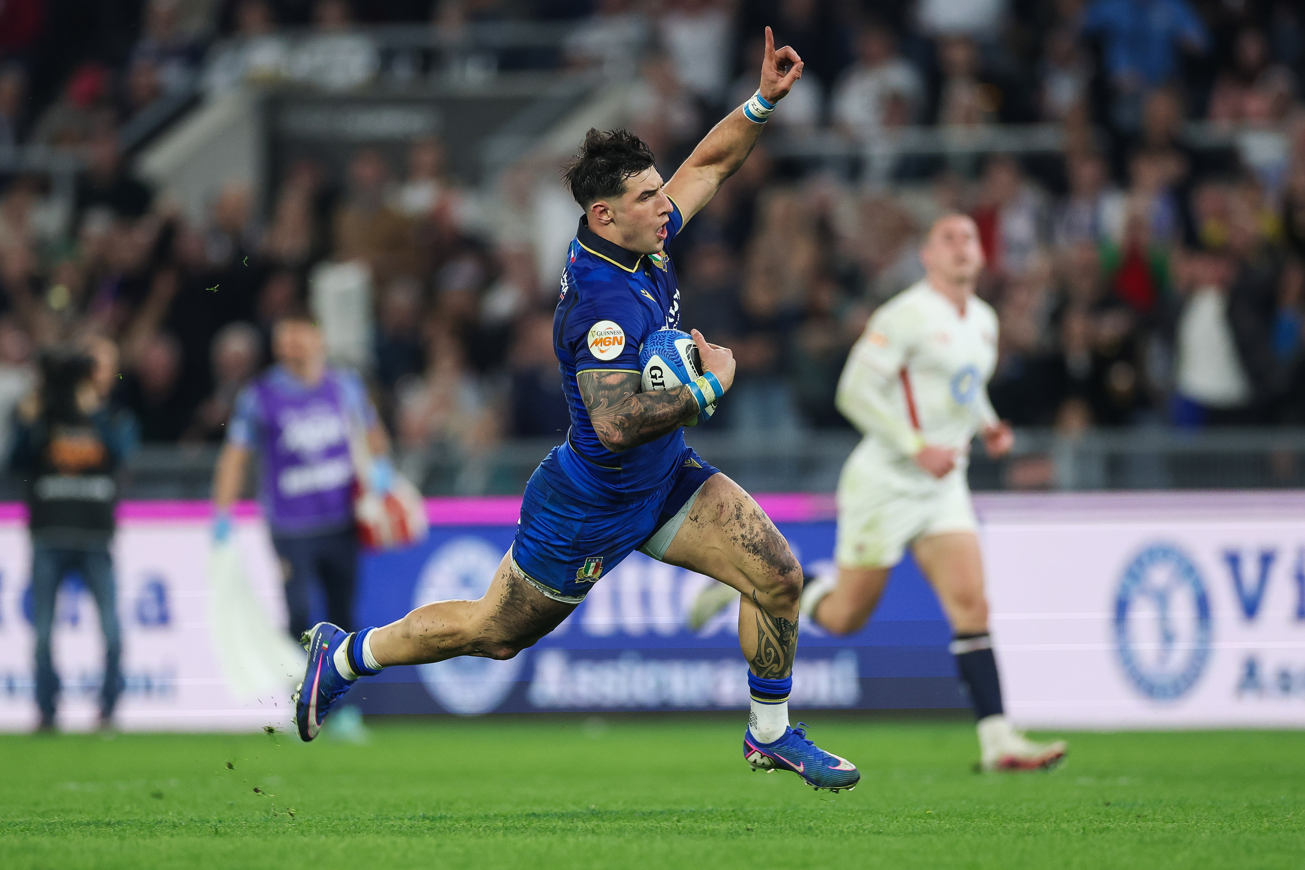 Tommaso Menoncello raises a hand in the air in celebration as he runs in a try for Italy against England in round four of the 2026 Championship.